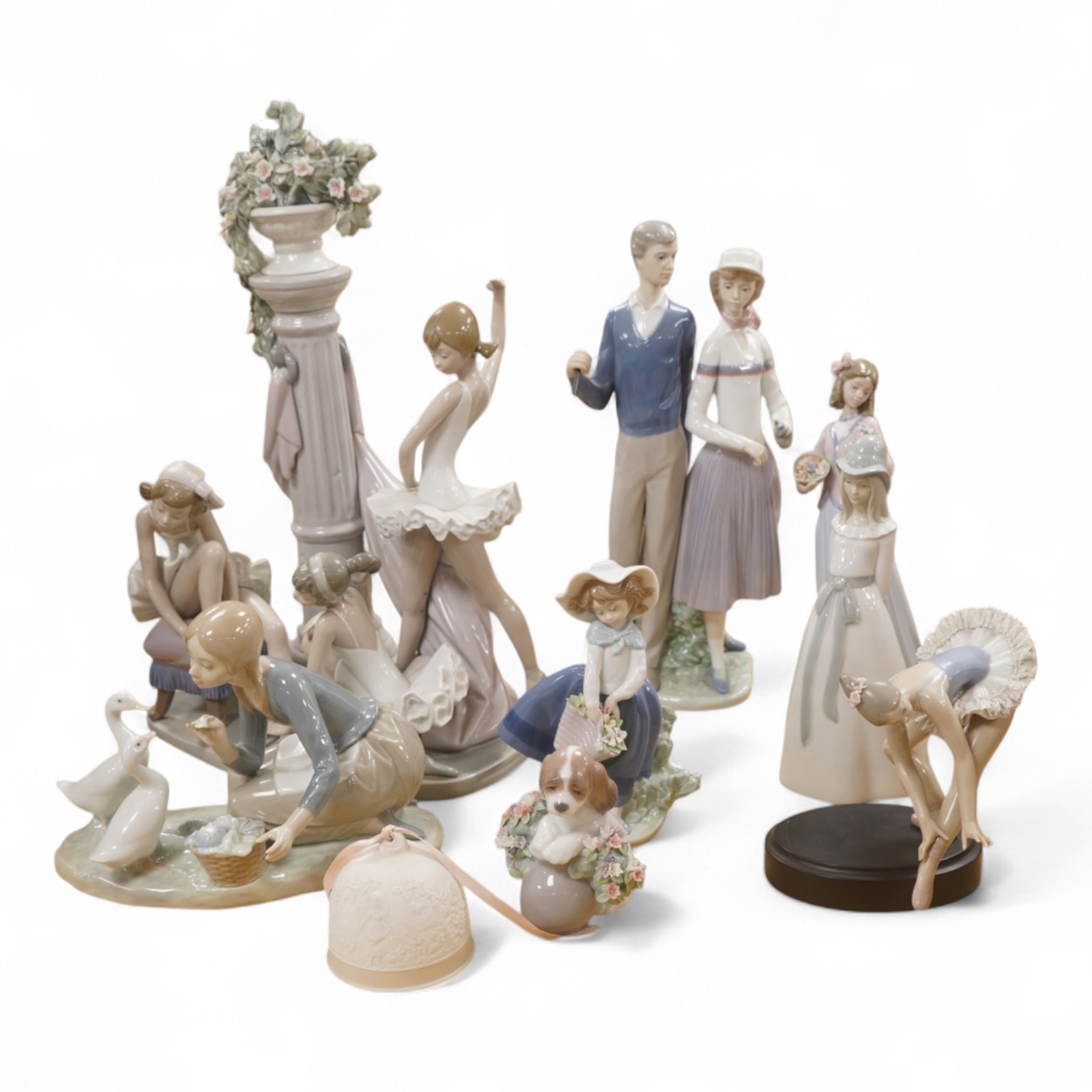 A large Lladro figure group of three ballet dancers by a tall floral column and eight other Lladro figures including a model of a bell. Tallest figure group 45cm high. Condition - golfer group, golf clubs broken.